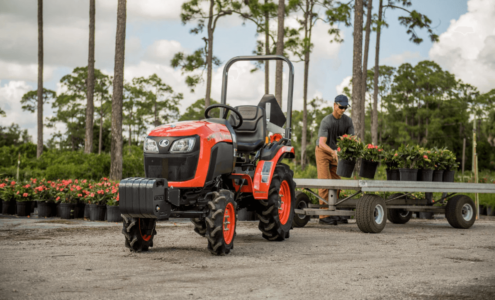 man loading flowers onto trailer behind kubota tractor